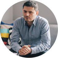 A man sitting down with his hands clasped